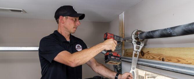 Specialist working on the top of the interior of a garage door.