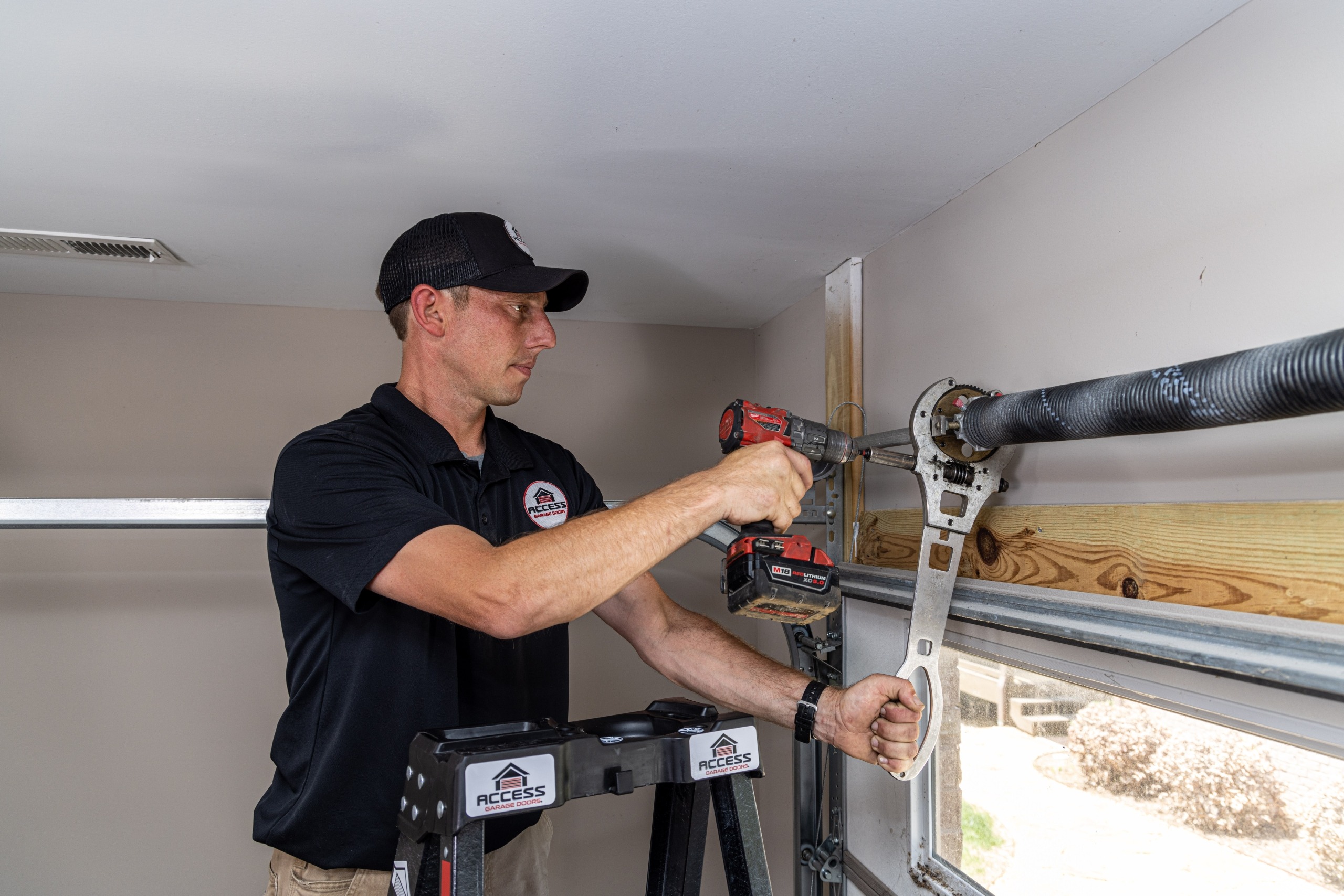 Specialist working on the top of the interior of a garage door.