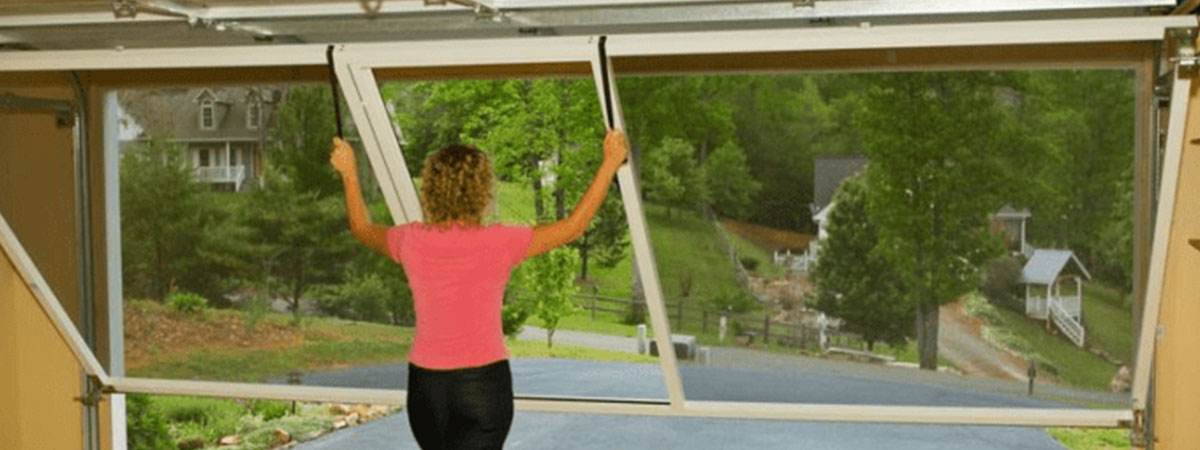 Woman letting down garage door screen