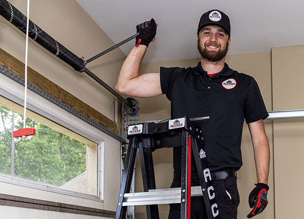 Access Garage Door & More installer smiling while making repairs